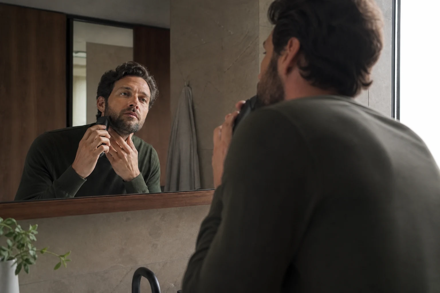 Adult carefully trimming the outline of his beard